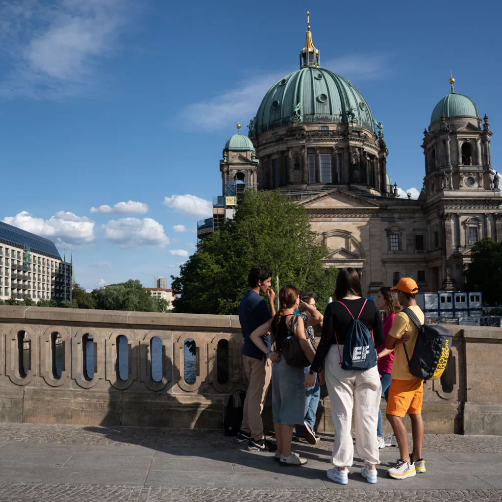 Students admire the Berlin Cathedral from a bridge, enjoying iconic architecture and a memorable cultural sightseeing experience
