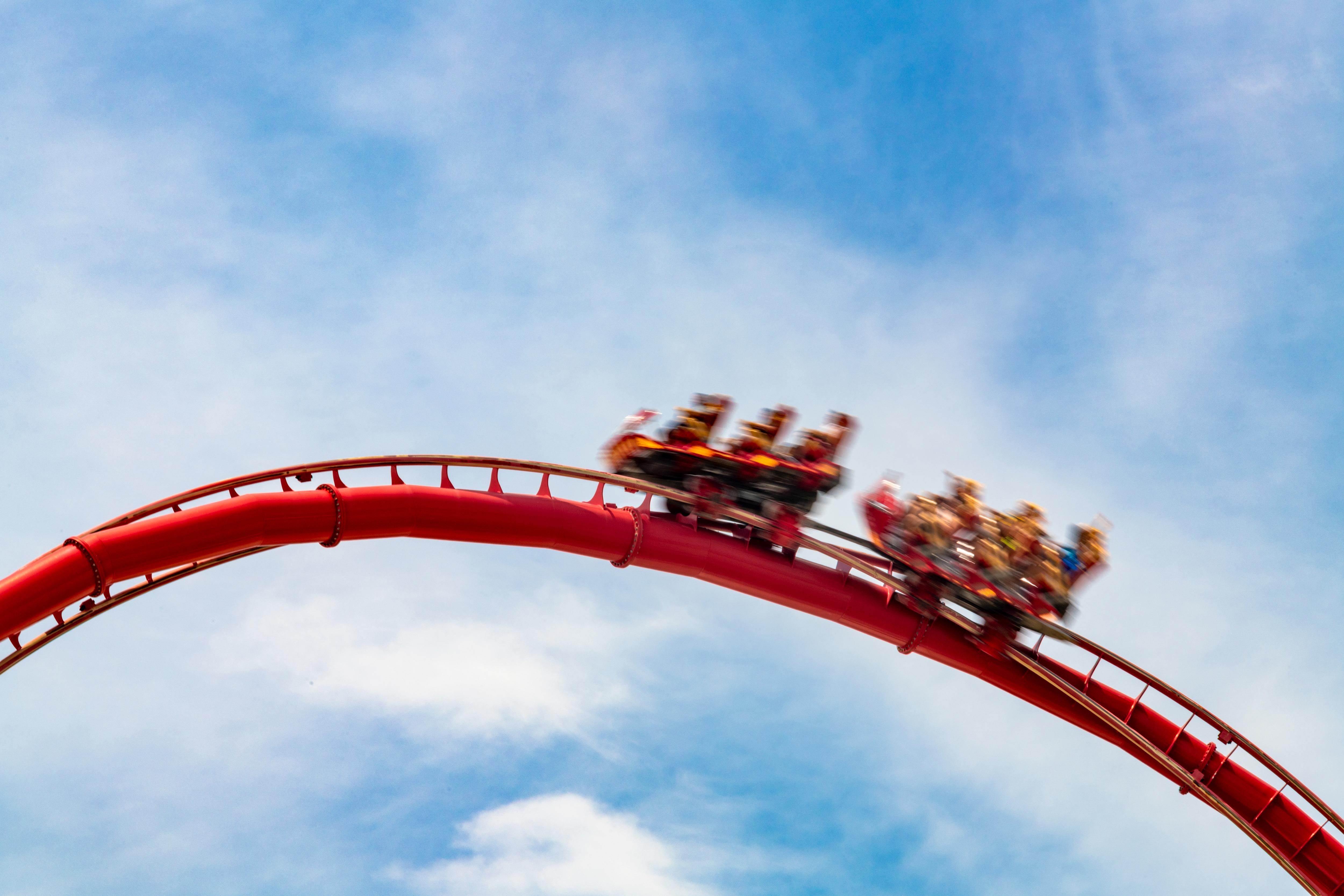 Thrilling Roller Coaster Ride Speeding Across Bright Blue Skies
