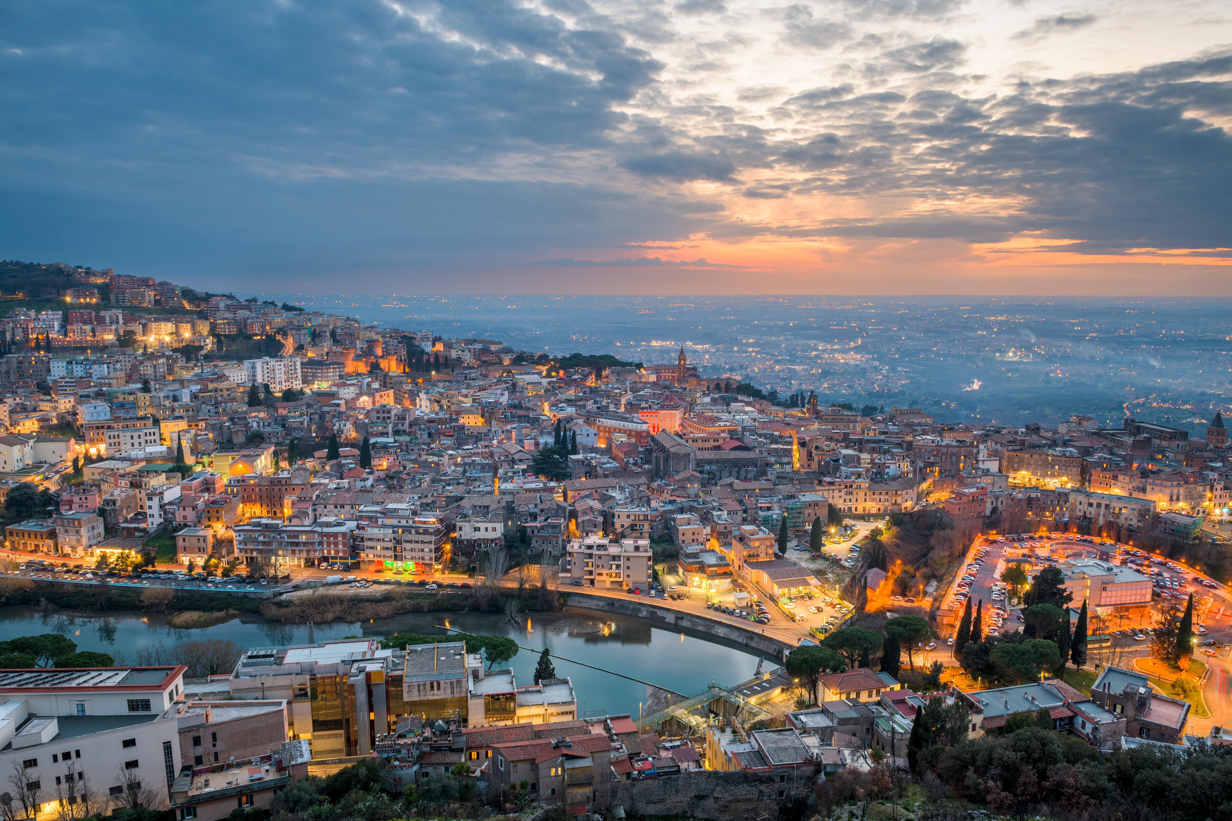 Italian cityscape at sunset with historic architecture beneath a dramatic sky