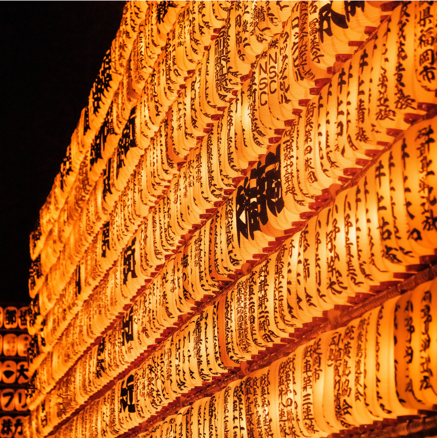 Traditional Japanese lanterns illuminated at night, creating a warm and festive cultural atmosphere