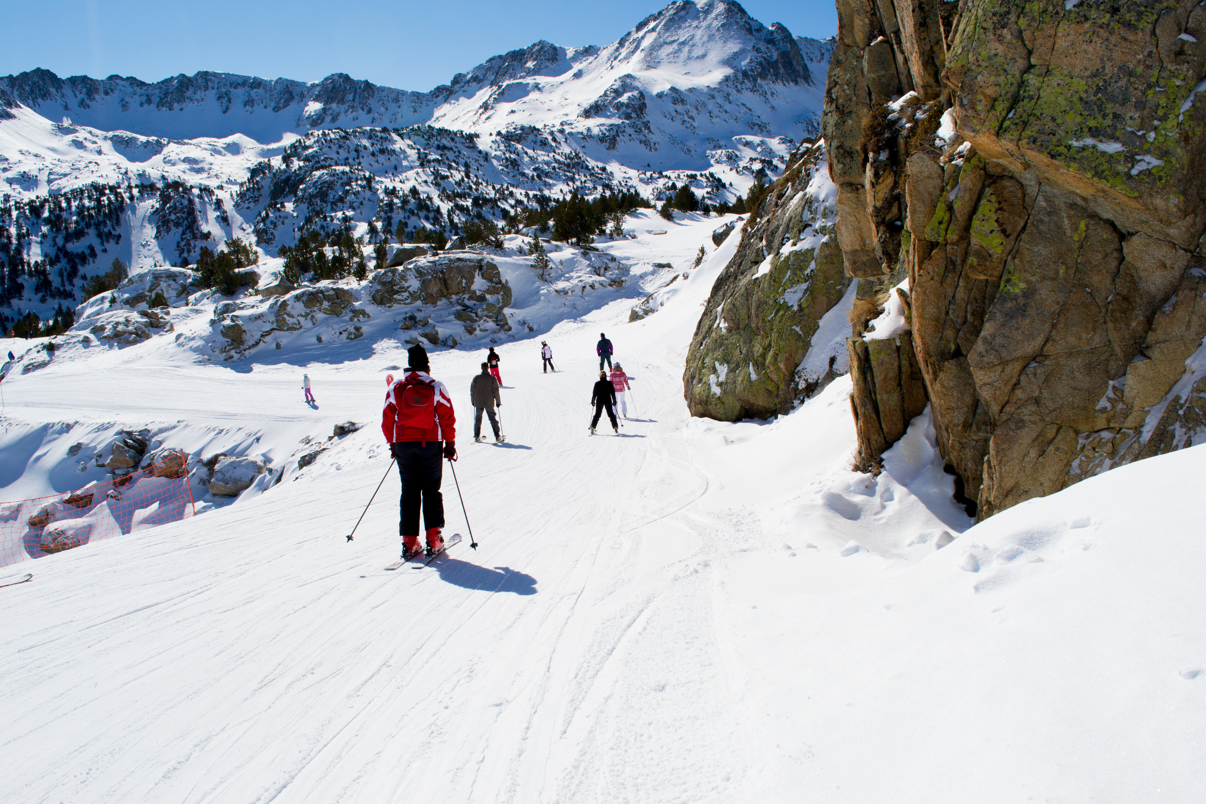 Students skiing on a snowy mountain slope with scenic alpine