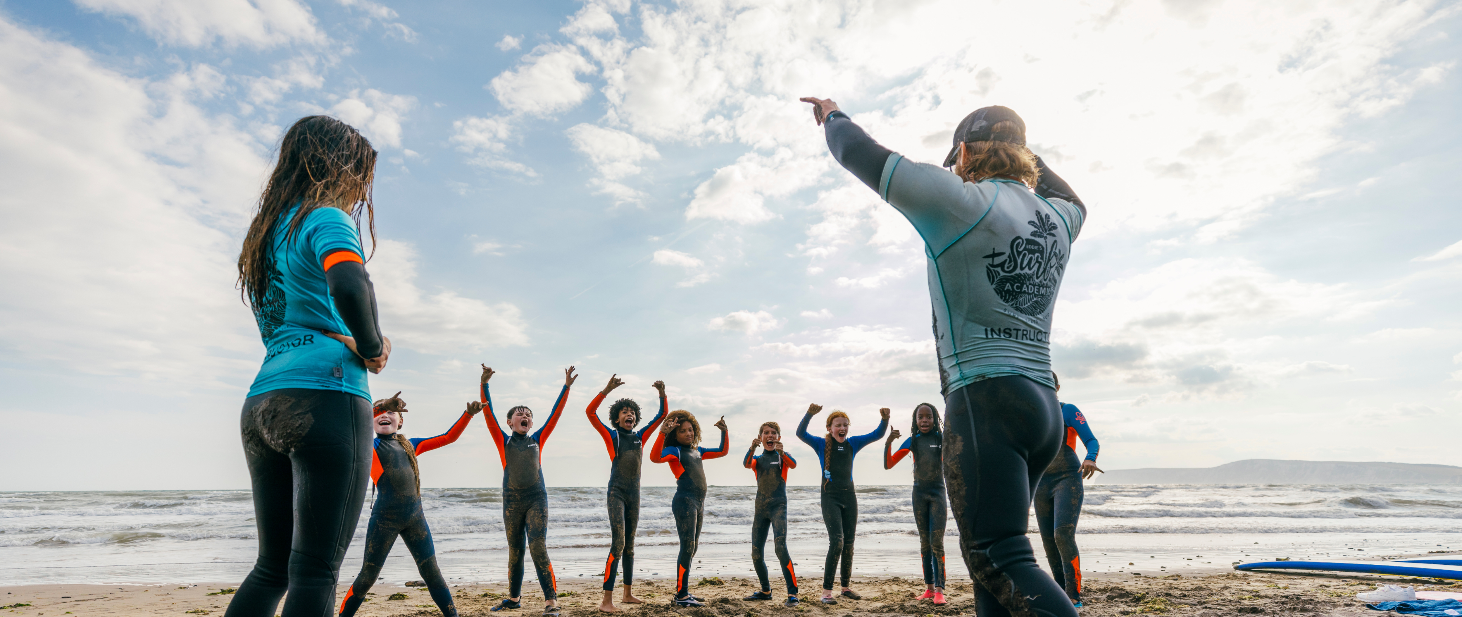 Students And Staff At Beach