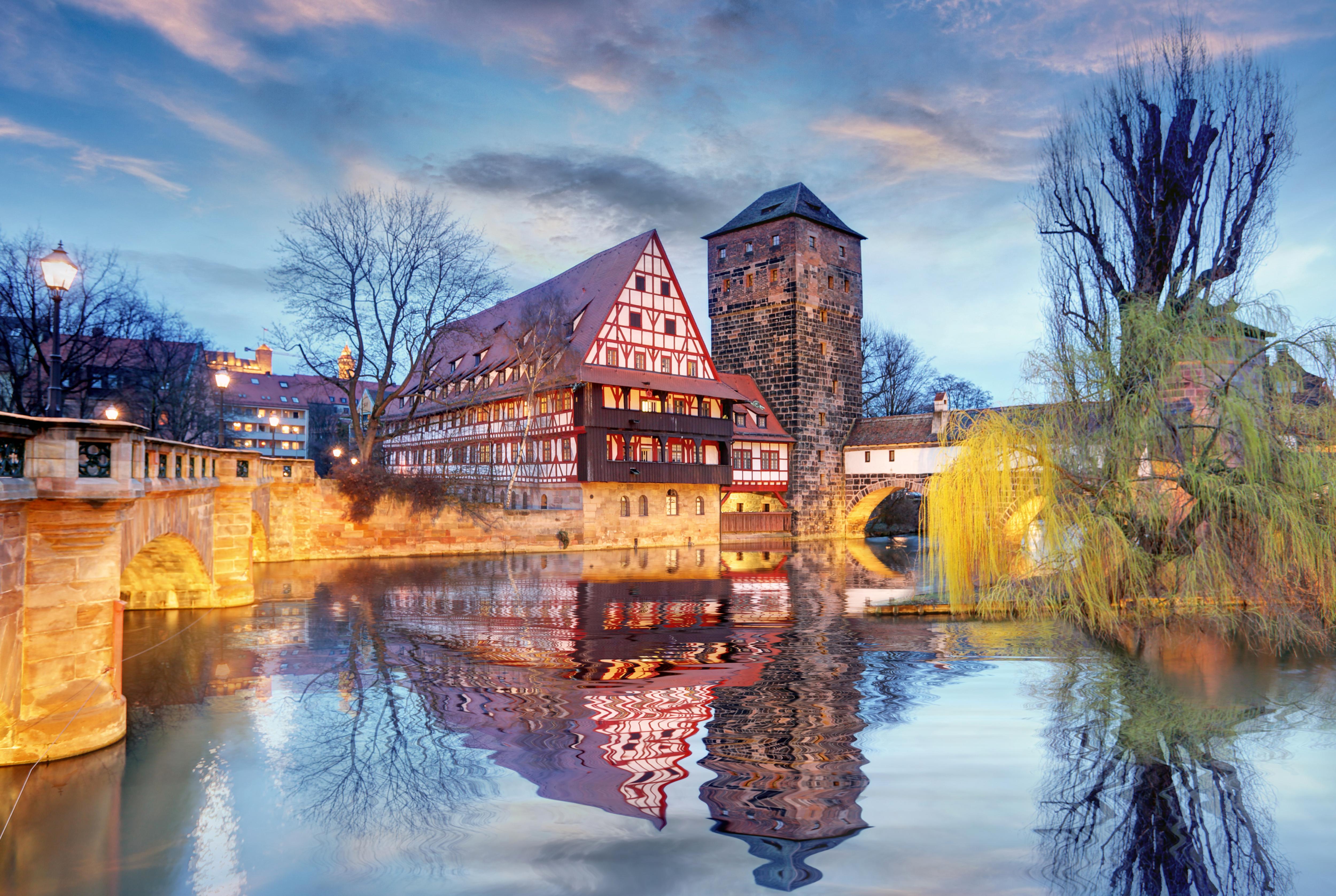 Weinstadel along the Pegnitz River at night, with reflections on the water