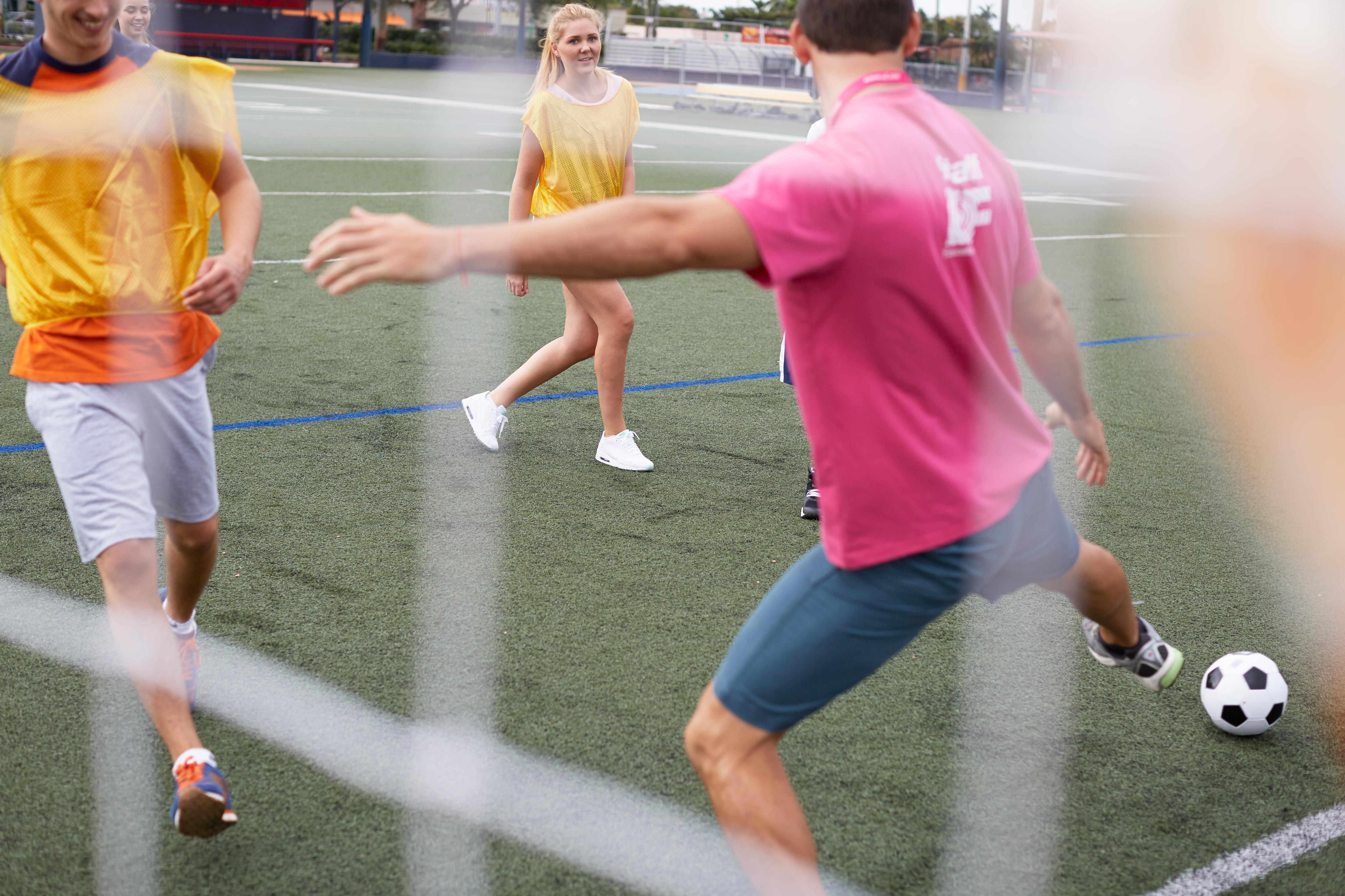 Students and staff enjoy a friendly soccer match, participating in an active and engaging sports activity