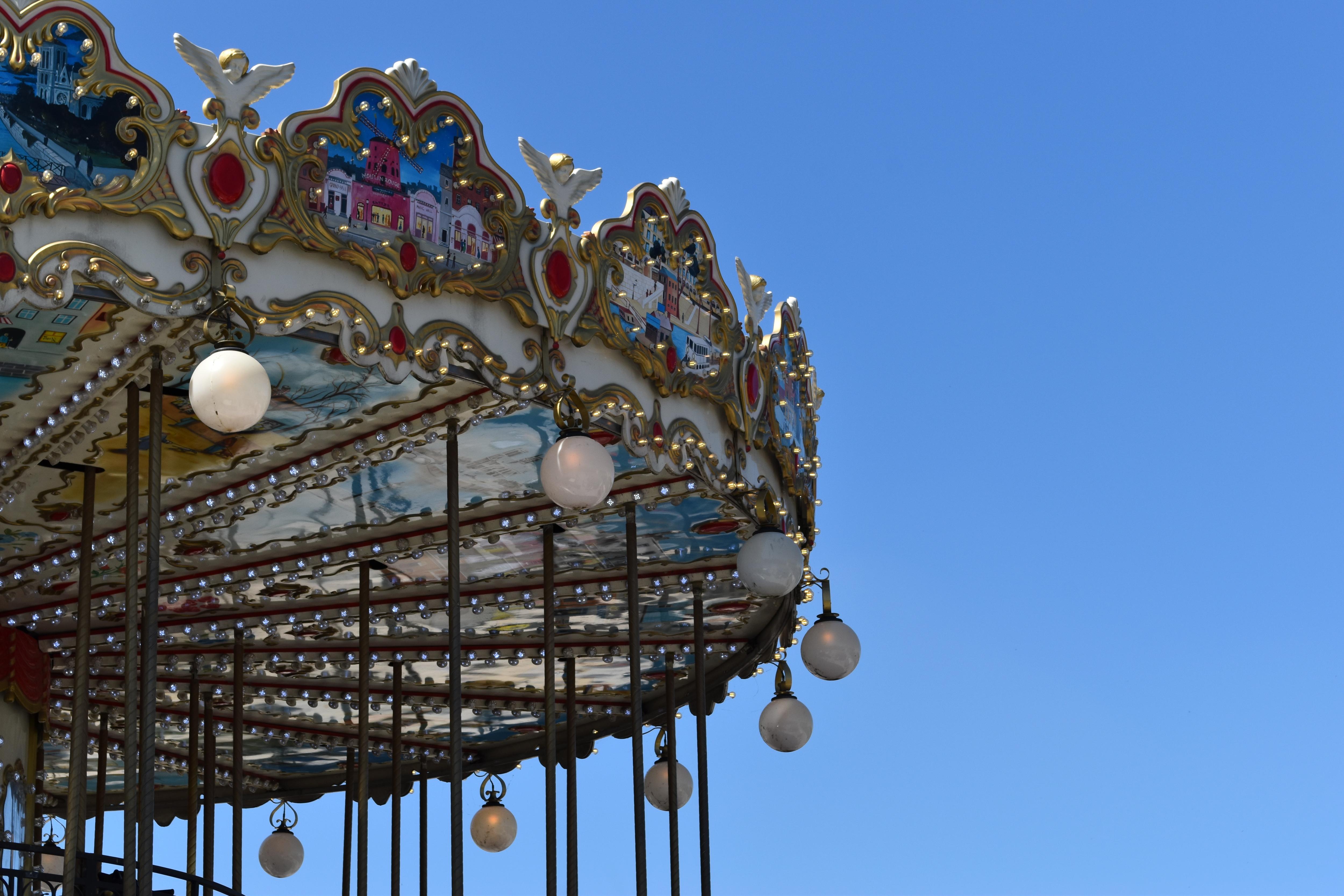 Close-up of an illuminated carousel canopy against a clear blue sky