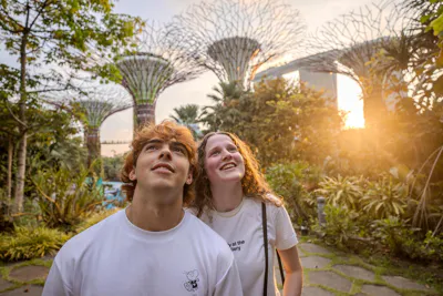 Two EF Language Abroad students enjoying Gardens by the Bay in Singapore, looking up at the Supertrees while exploring the city during sunset.