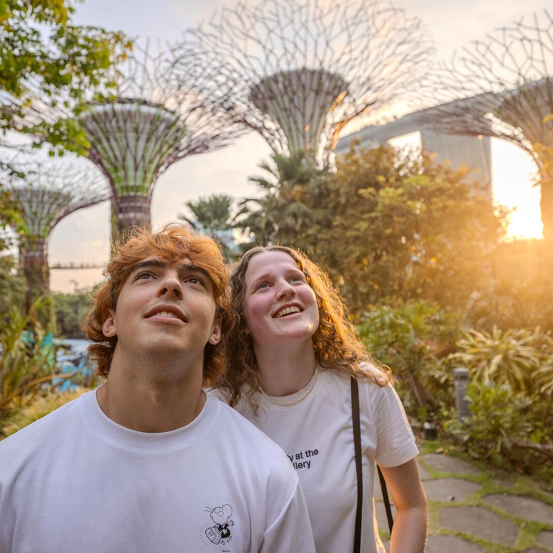 Two EF Language Abroad students enjoying Gardens by the Bay in Singapore, looking up at the Supertrees while exploring the city during sunset.