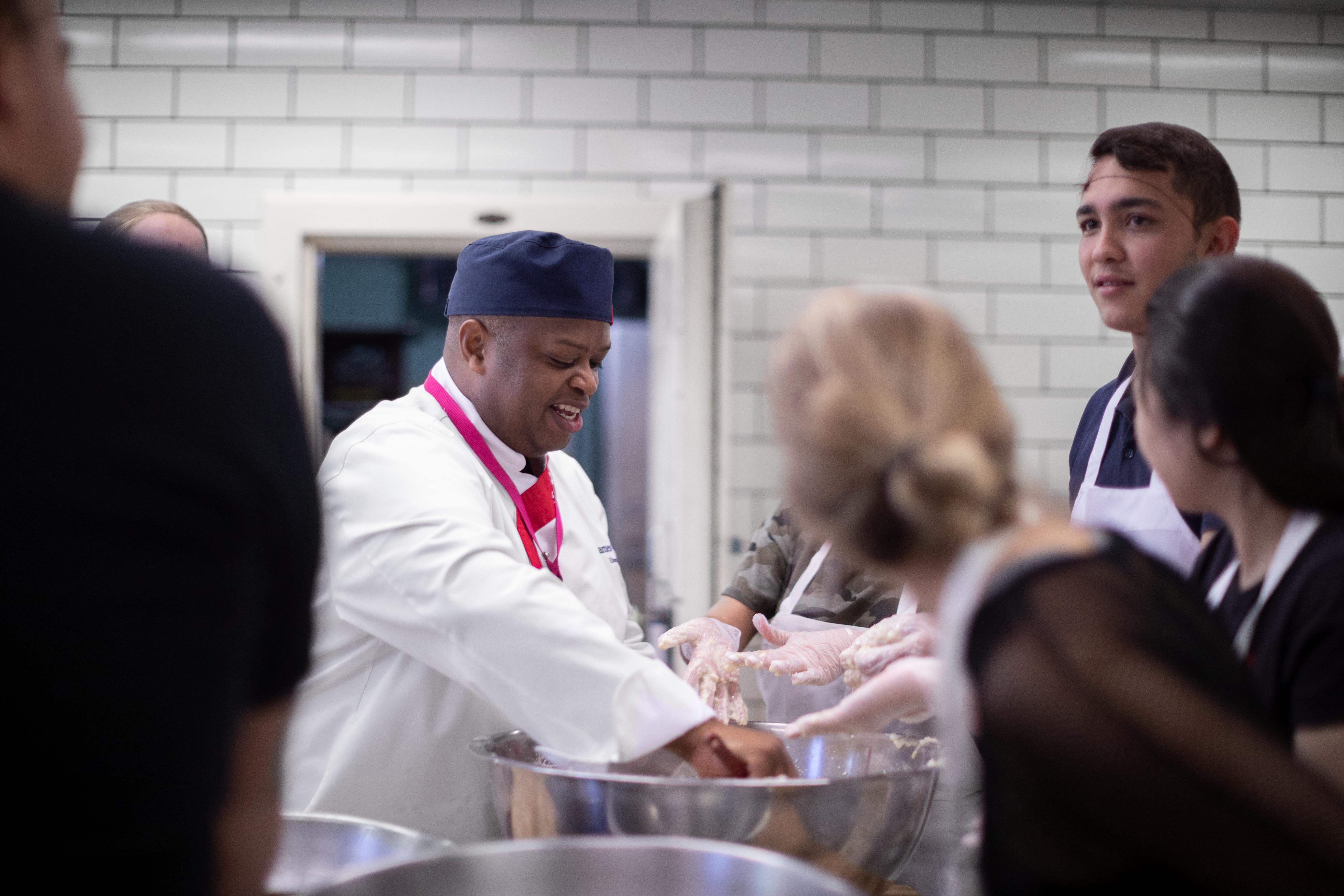 Chef demonstrates cooking techniques to students during an interactive culinary workshop