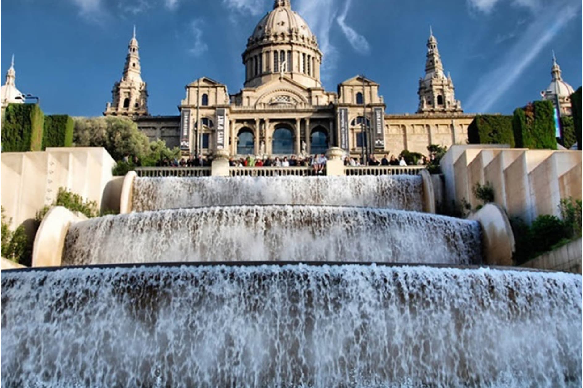 This image captures the magnificent Palau Nacional in Barcelona, Spain, featuring its iconic cascading fountains that create a majestic backdrop. It's a landmark that draws visitors from all over the globe.