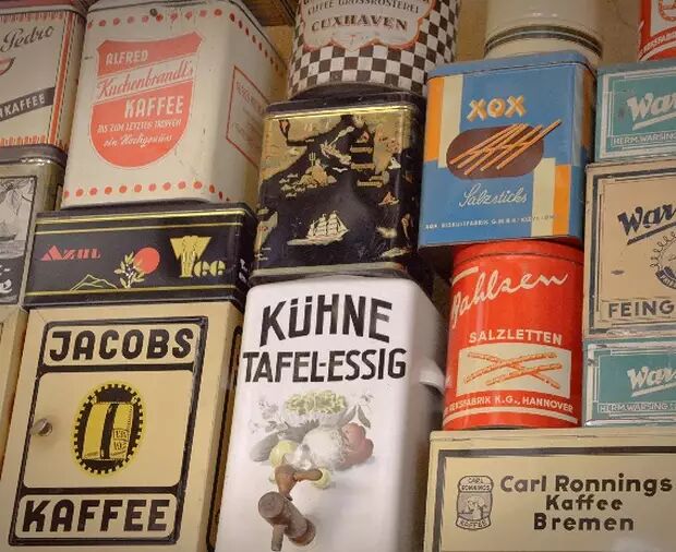 This image displays a collection of vintage German food tins, primarily featuring coffee and vinegar brands like Jacobs, Kühne, and Alfred Kuchenbrandl, showcasing retro typography and design.