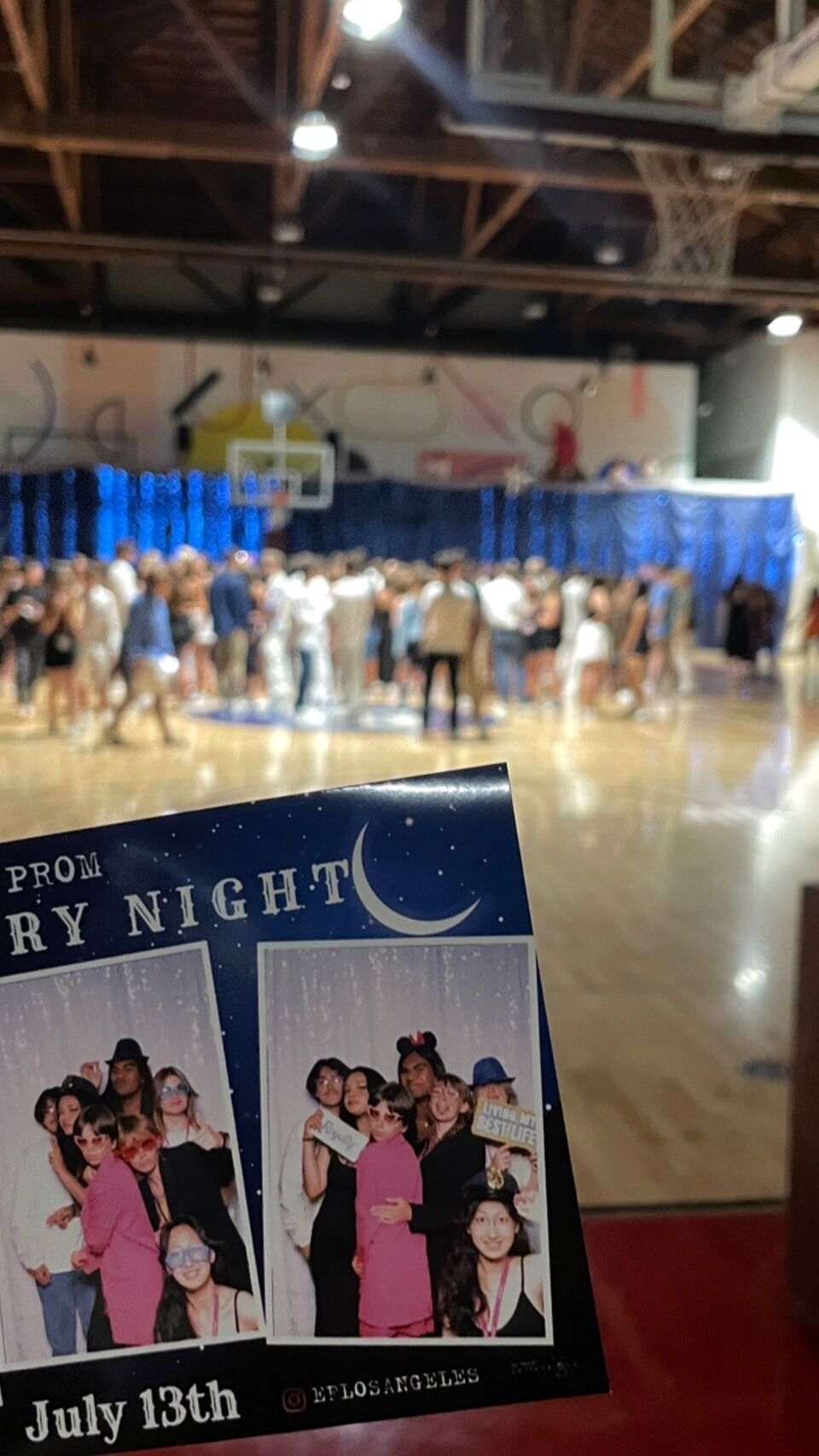 The image shows a prom night event, likely on July 13th, with a photo booth featuring groups of smiling people. The background appears to be a gymnasium decorated for the occasion.