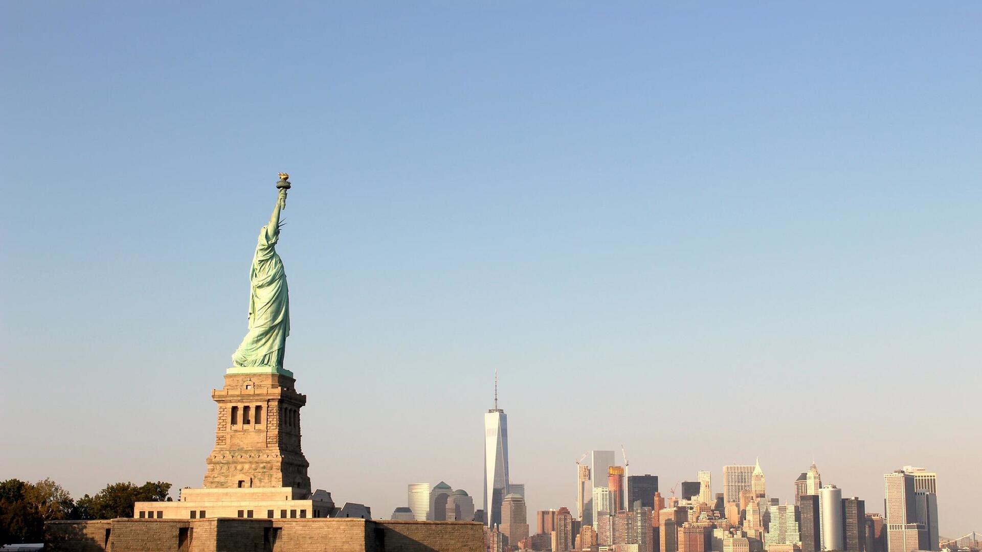 The Statue of Liberty stands majestically against the New York City skyline, an iconic monument symbolizing freedom and hope.