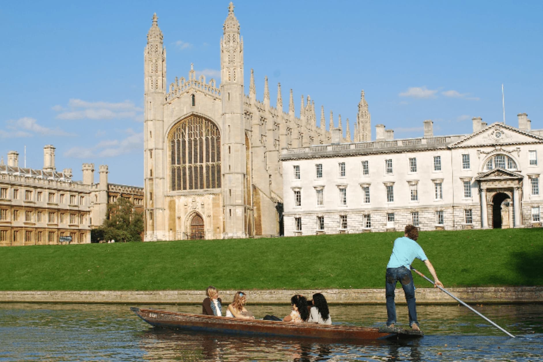 A group of people are punting on a river with a large, ornate building in the background. The building appears to be a historic university or cathedral with tall spires and arched windows.
