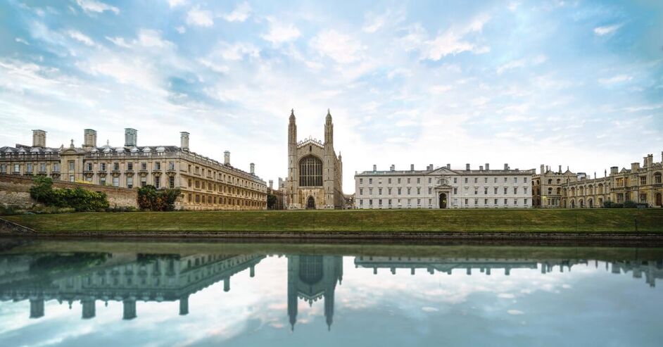 This image shows King's College Chapel in Cambridge, England, reflected in the River Cam on a cloudy day. The Gothic architecture of the chapel is a prominent feature.