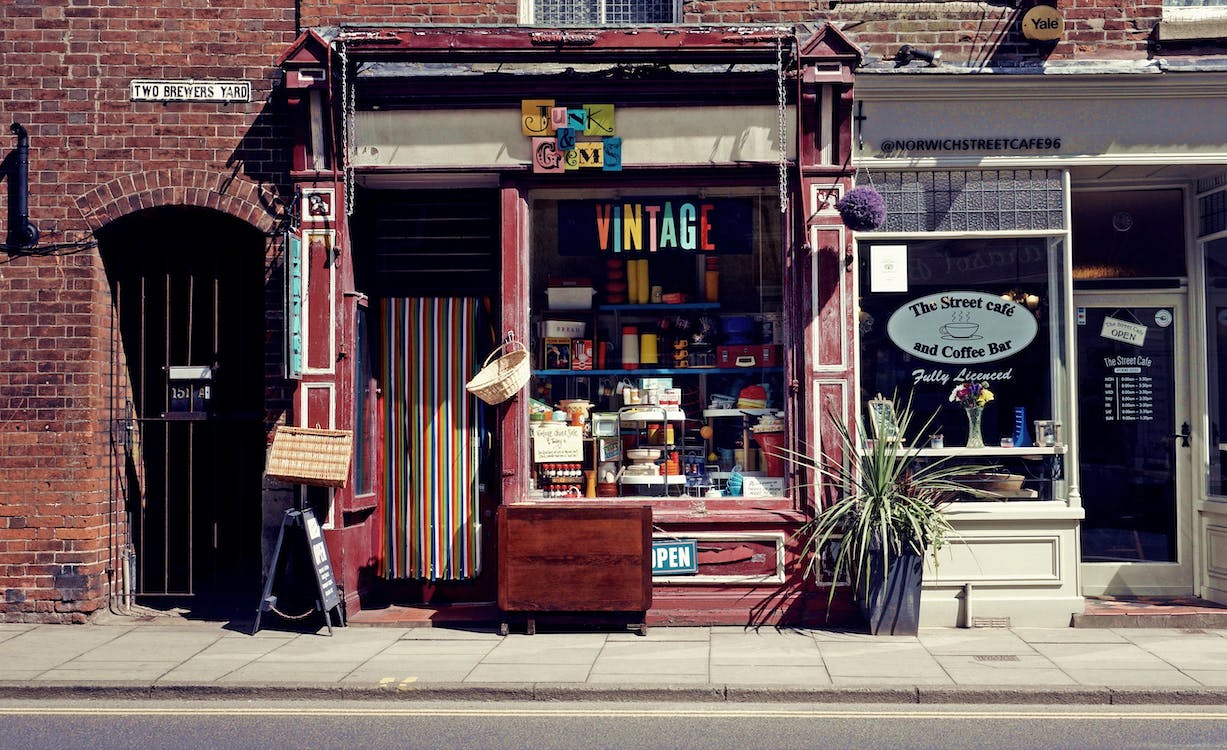 This is a charming vintage shop with a colorful striped curtain and a display of various items in the window. The sign above the door clearly indicates "VINTAGE".